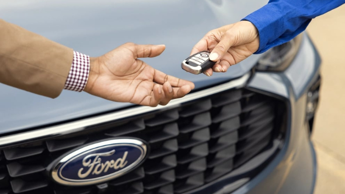Ford Dealership employee handing over new keys