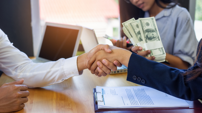 People at car dealership shaking hands