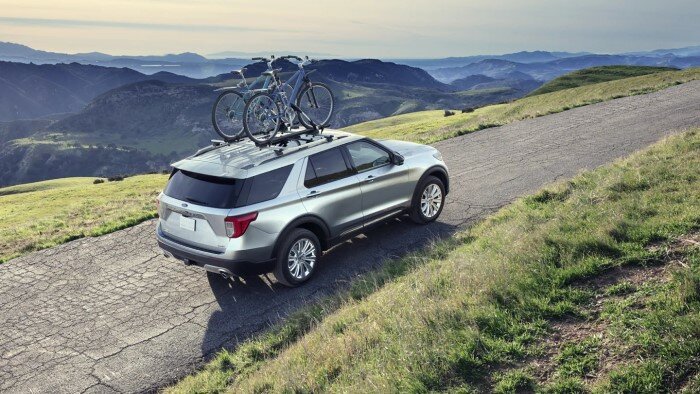 Silver Ford Explorer driving through a mountainous terrain.